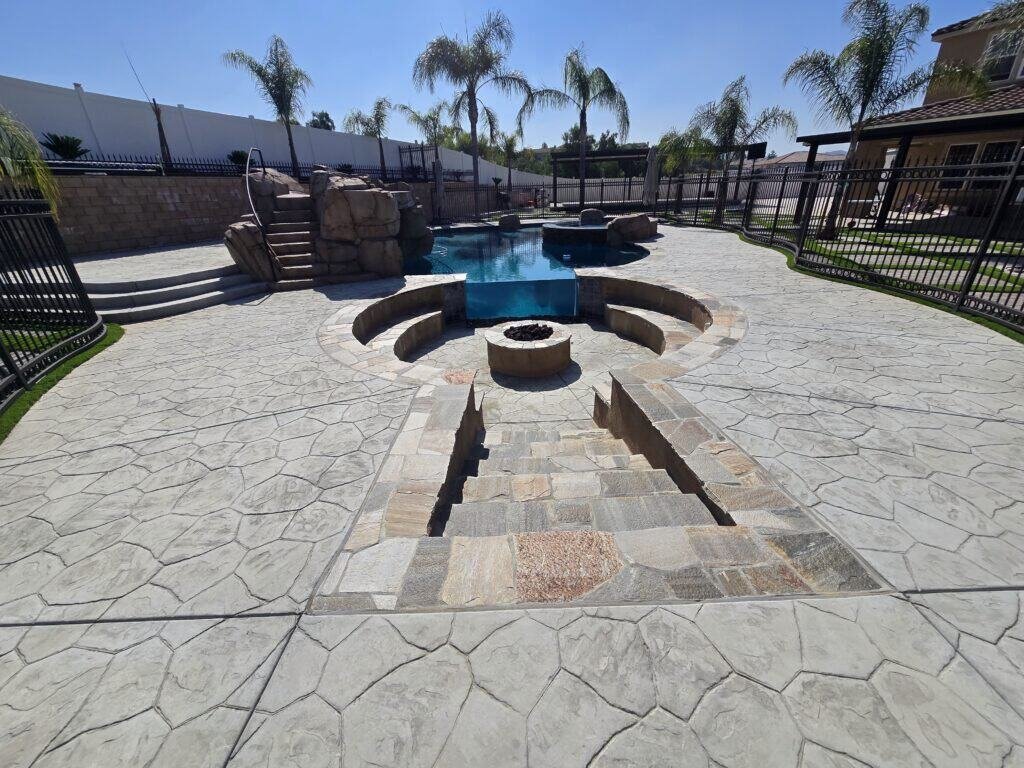 Spacious backyard featuring a custom-built pool, stone patio, and fire pit for outdoor entertaining.