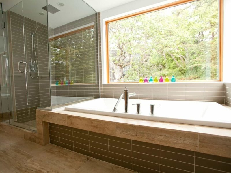 Spacious bathroom featuring a large bathtub and a separate glass-enclosed shower with modern fixture.